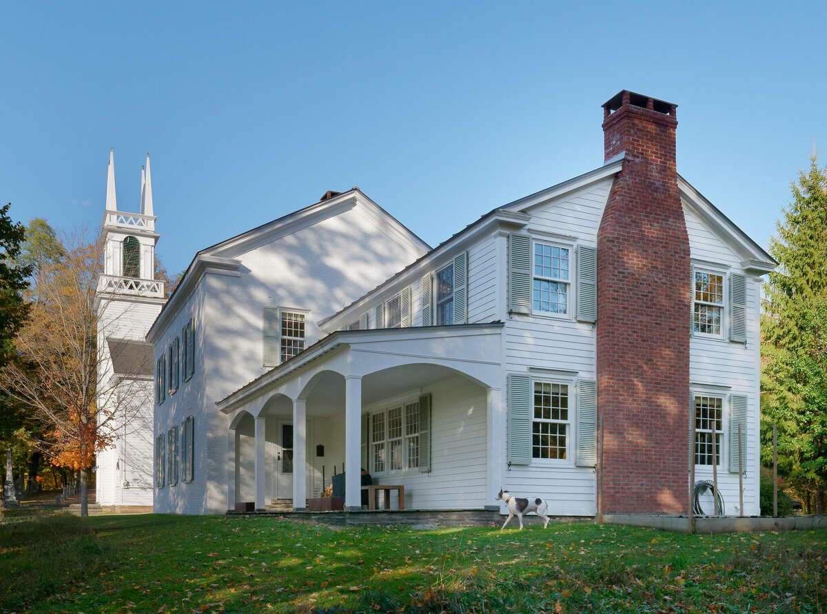 A historic home privately situated beside a church atop a hill with incredible views of southern Albany County, and an adorable studio out building? Yes, please. This retreat-like 1830 painted brick Federal-style home located at 14 Trinity Lane in Rensselaerville was once a parsonage for clergy at the adjacent church which is still in use today. The home oozes charm and features four bedrooms, a formal parlor, an assortment of built-ins and a mix of carpet and hardwood flooring. A whimsical fish motif wallpaper emblematic of Italian artist Piero Fornasetti's (1913-1988) work in one of the three-and-a-half bathrooms is particularly eye-catching. French doors in the farmhouse-style kitchen open to a pond and butterfly garden. On the literal edge of the property sits a quaint building that would make a great office, studio or cozy place to escape.  Listing price: $699,000. Taxes: $10,800. To learn more, contact listing agent James T. Male with HOUSE Hudson Valley Realty at james@househudsonvalley.com or (518) 697-9390.