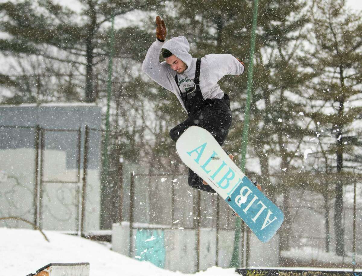 Chris Bewick of Ghent enjoys the new snow snowboarding at the skatepark in Washington Park during a snow storm on Tuesday, March 14, 2023 in Albany, N.Y.