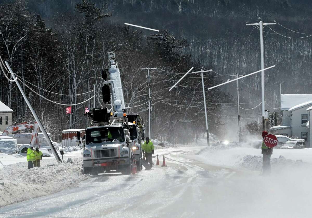 National Grid crews repair a utility pole on Route 443 near Meadow Brook Farms Dairy as a fierce wind blows snow from the lines on Wednesday, March 15, 2023, in Clarksville, N.Y.