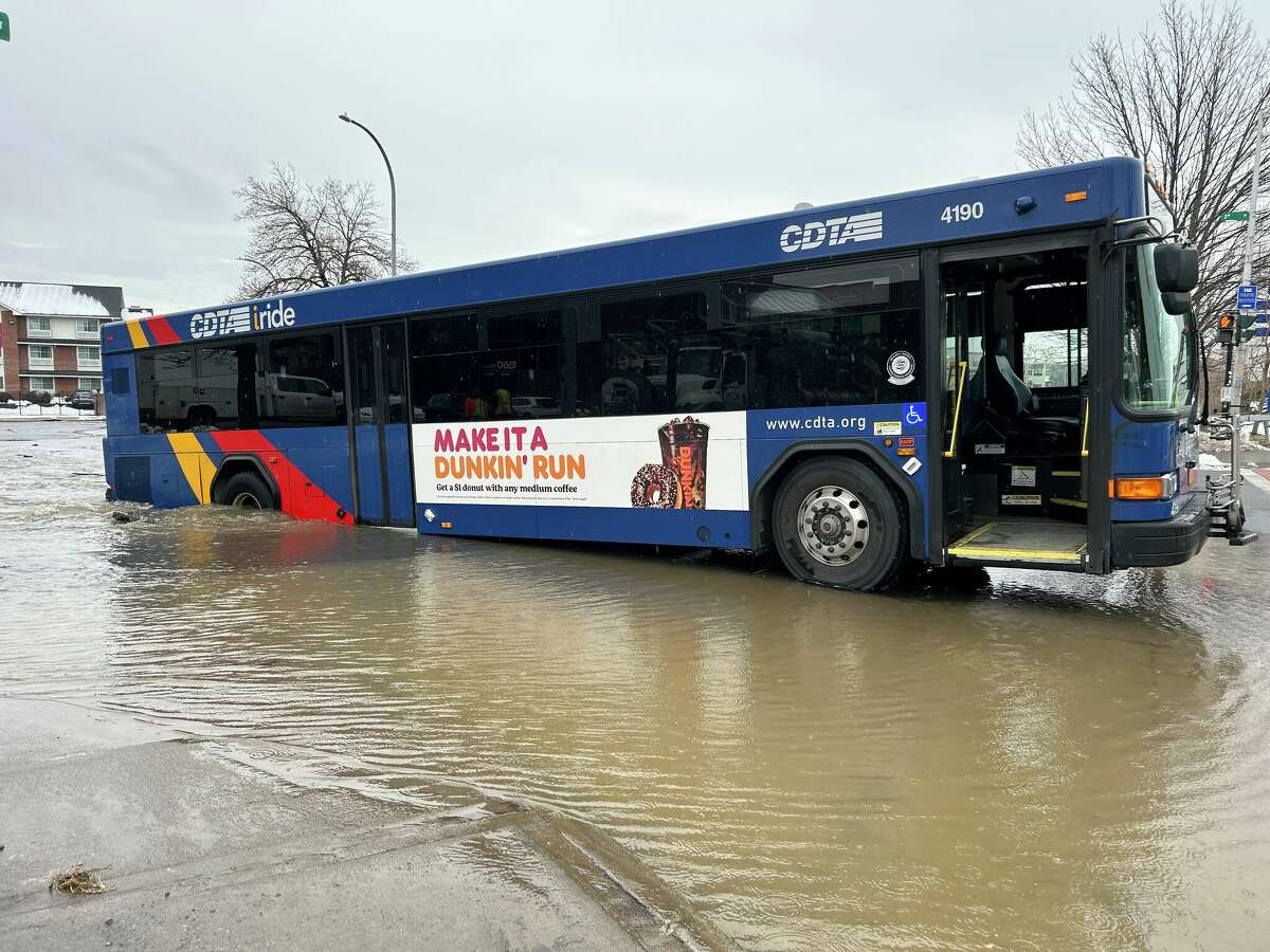 A CDTA bus is partially submerged in a sinkhole on Fourth Street in Troy near the corner of Federal Street after a water main break in Friday morning.