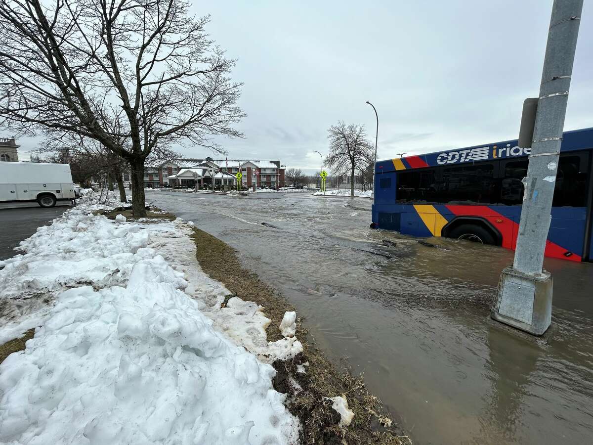 A CDTA bus is partially submerged in a sinkhole on Fourth Street in Troy near the corner of Federal Street after a water main break in Friday morning.