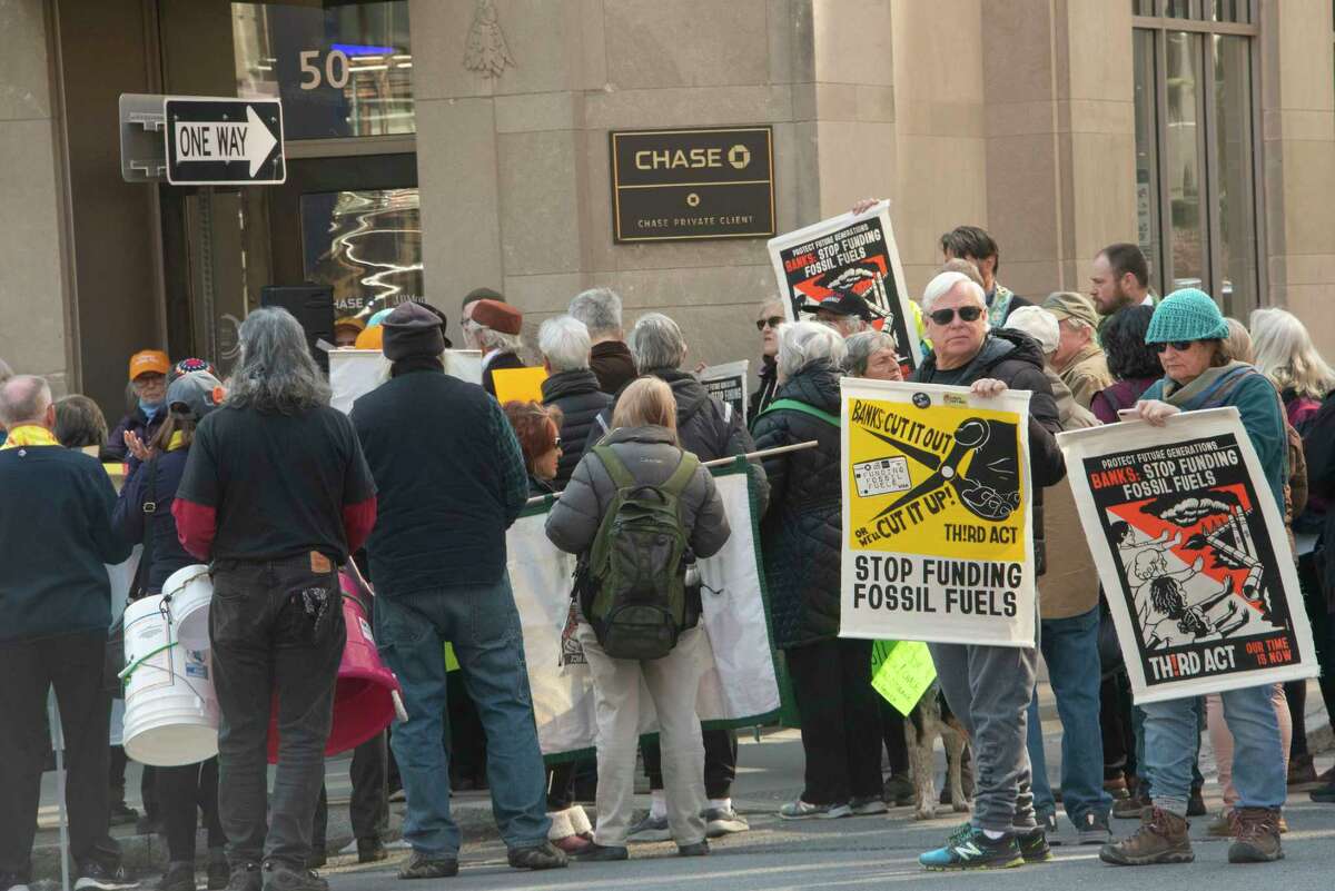 People participate in a climate march downtown to protest banks financing the fossil fuel industry on Tuesday, March 21, 2023 in Albany, N.Y.