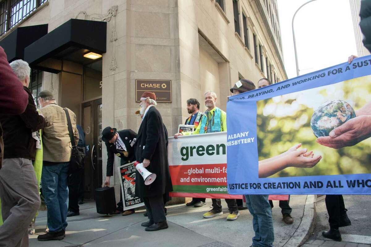 People participate in a climate march downtown to protest banks financing the fossil fuel industry on Tuesday, March 21, 2023 in Albany, N.Y.