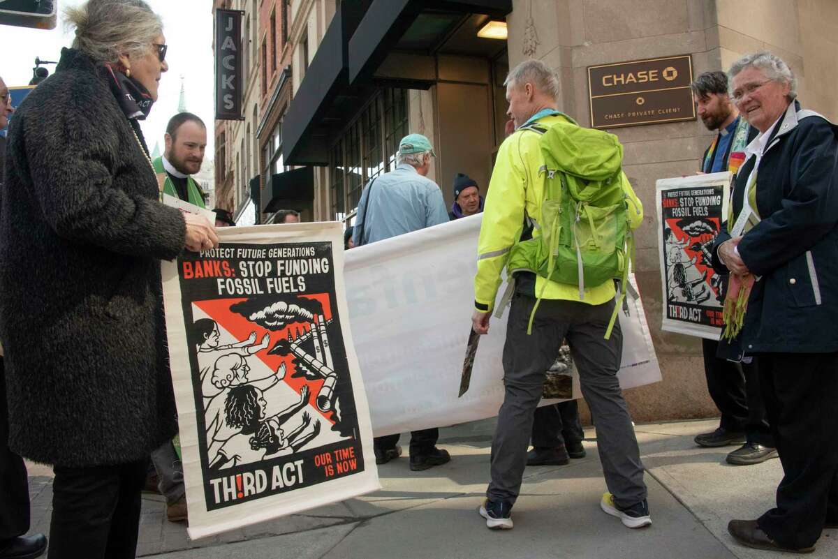 People participate in a climate march downtown to protest banks financing the fossil fuel industry on Tuesday, March 21, 2023 in Albany, N.Y.