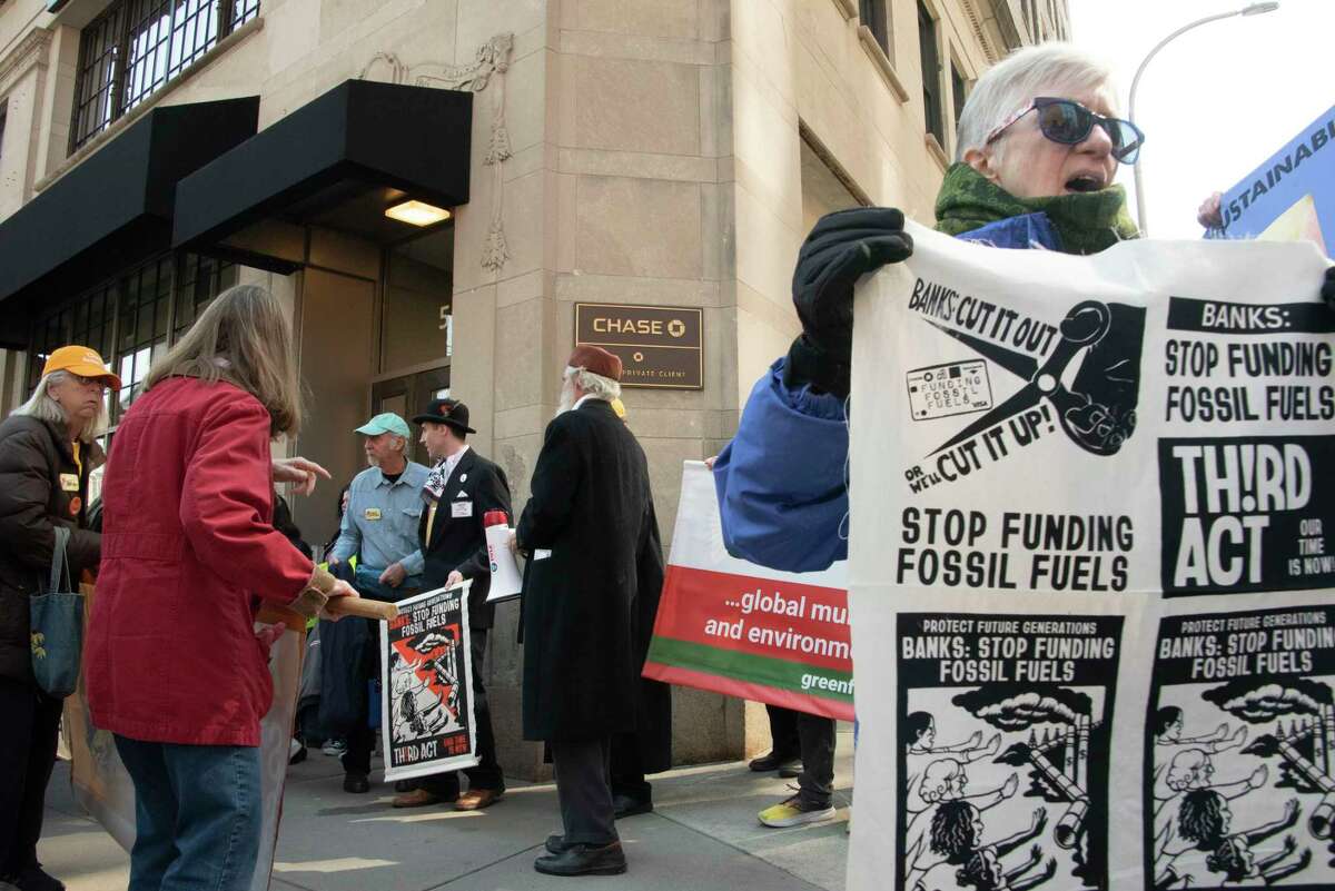 People participate in a climate march downtown to protest banks financing the fossil fuel industry on Tuesday, March 21, 2023 in Albany, N.Y.