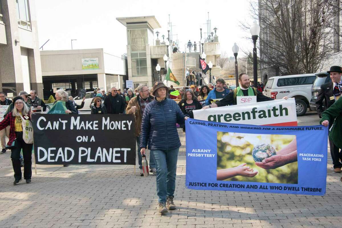 People participate in a climate march downtown to protest banks financing the fossil fuel industry on Tuesday, March 21, 2023 in Albany, N.Y.