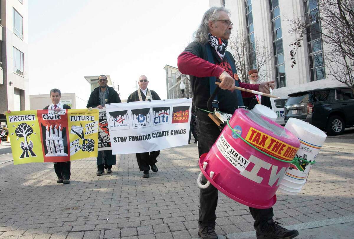 People participate in a climate march downtown to protest banks financing the fossil fuel industry on Tuesday, March 21, 2023 in Albany, N.Y.