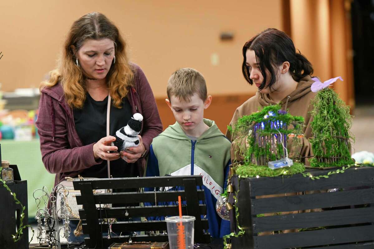 From left: Debbie, Chase and Laura Hoover peruse merchandise during a village-wide craft and vendor fair on Saturday, April 1, 2023, in Altamont, NY.