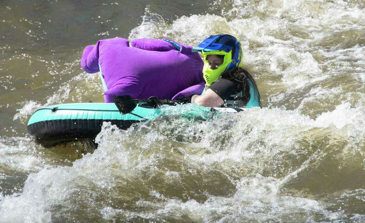 Barney the dinosaur falls off a boat in the Anything That Floats Regatta in the 48th Annual Tenandeho White-Water Derby on the Anthony Kill on Sunday April 2, 2023 in Mechanicville, N.Y.