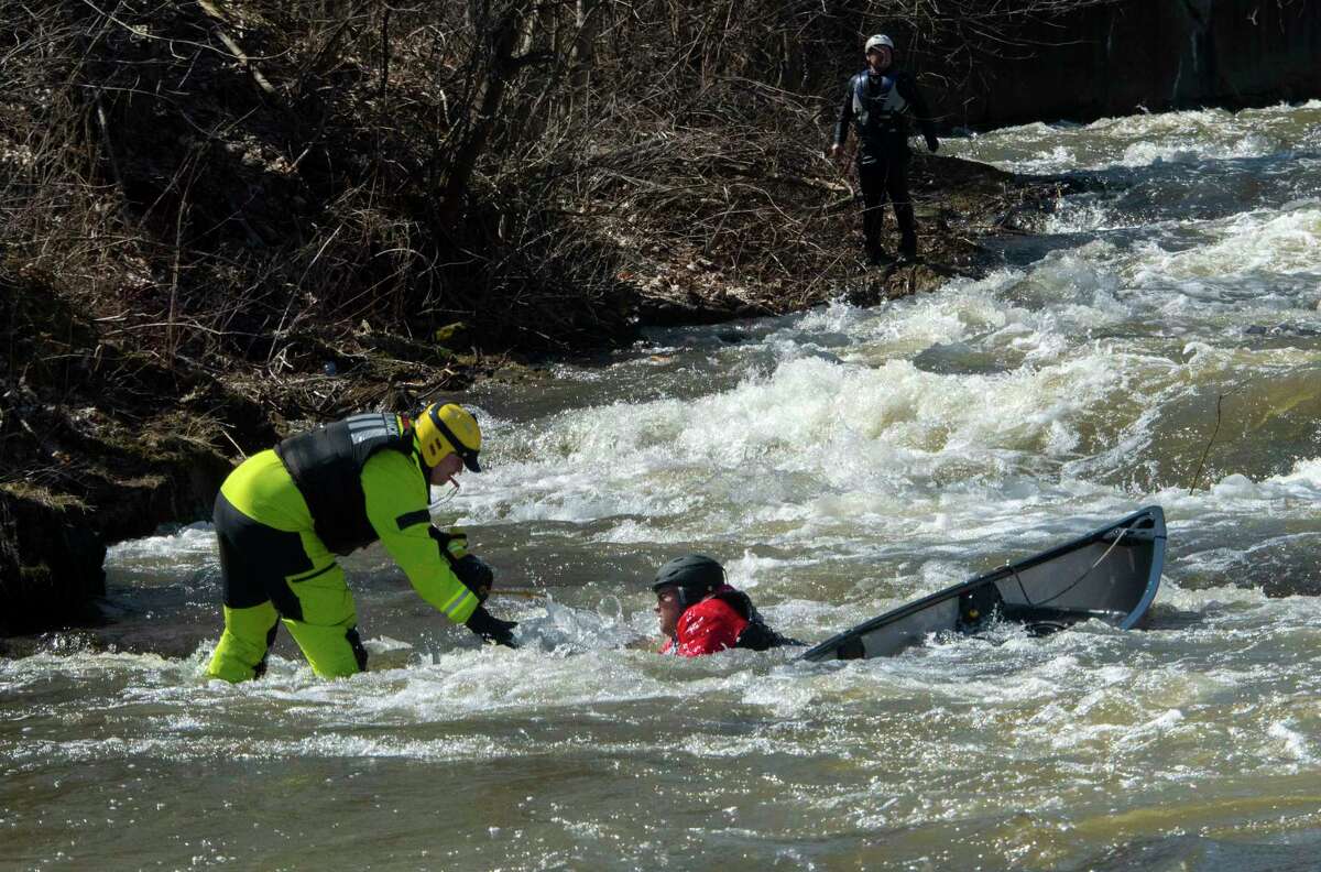 A saftey member helps a participant who fell out of their canoe as they compete in the 48th Annual Tenandeho White-Water Derby on the Anthony Kill on Sunday April 2, 2023 in Mechanicville, N.Y.