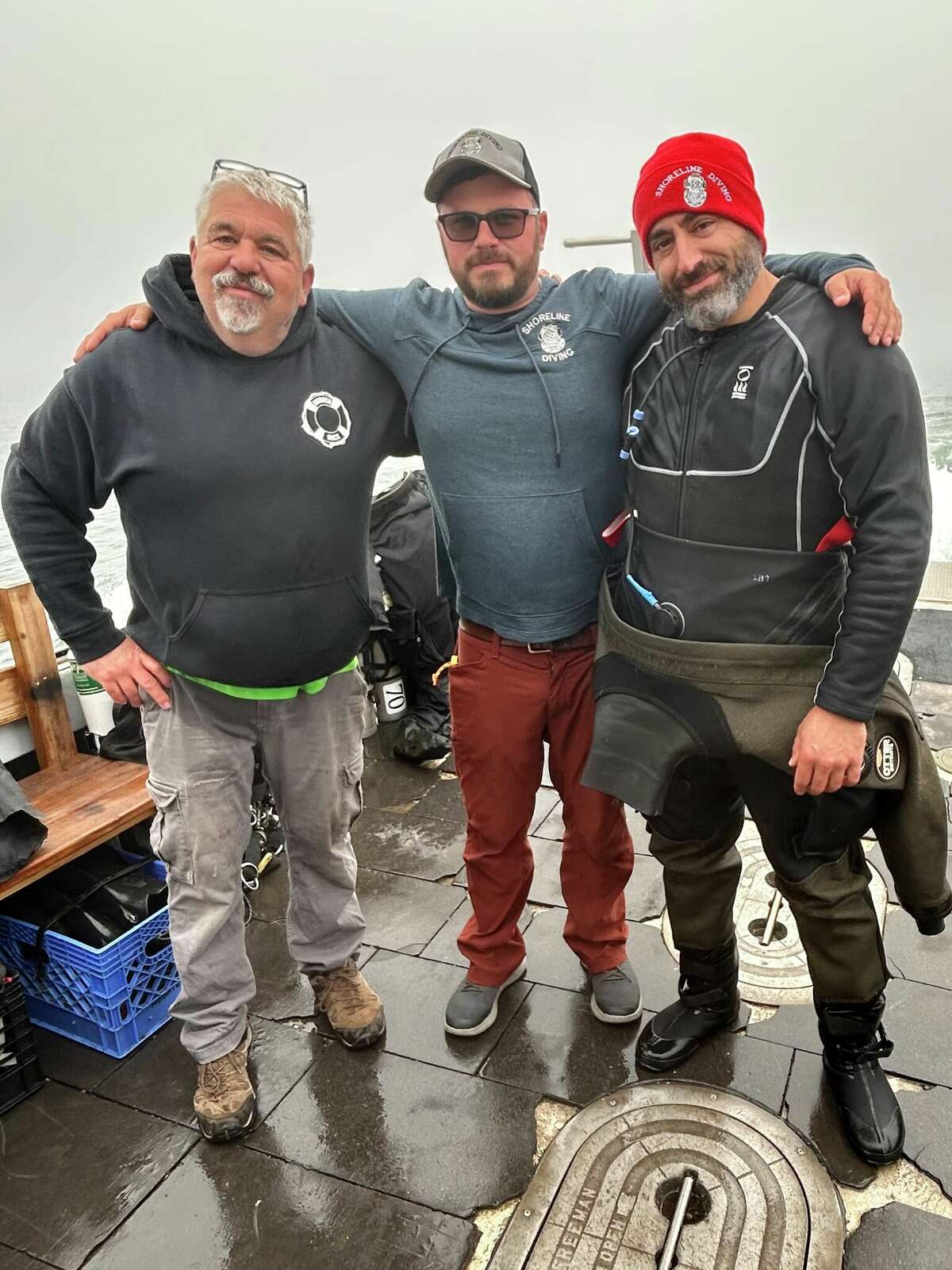 Richard Simon, with divers Steve Abbate, left, and Joe Mazraani, right, after their dive to the wreck they believe is the Defender.