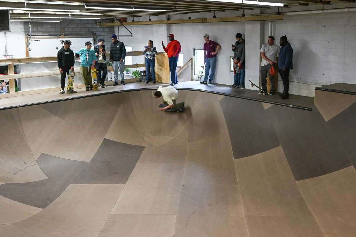 Skateboarders watch Chevy Rose skate around the bowl during the grand opening of the Noteworthy Community Center’s indoor skate park on Saturday, April 29, 2023, on Broadway in Albany.