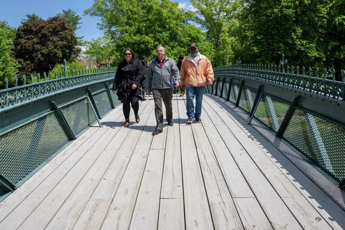 From left: Karen Sklenarik, Robert Sklenarik and Vernon Watson cross the bridge in Washington Park during the 13th annual VA2K Walk and Roll fundraiser held to support the Homeless Veterans Program at the Samuel S. Stratton Department of Veterans Affairs Medical Center on Wednesday, May 17, 2023, in Albany, NY.