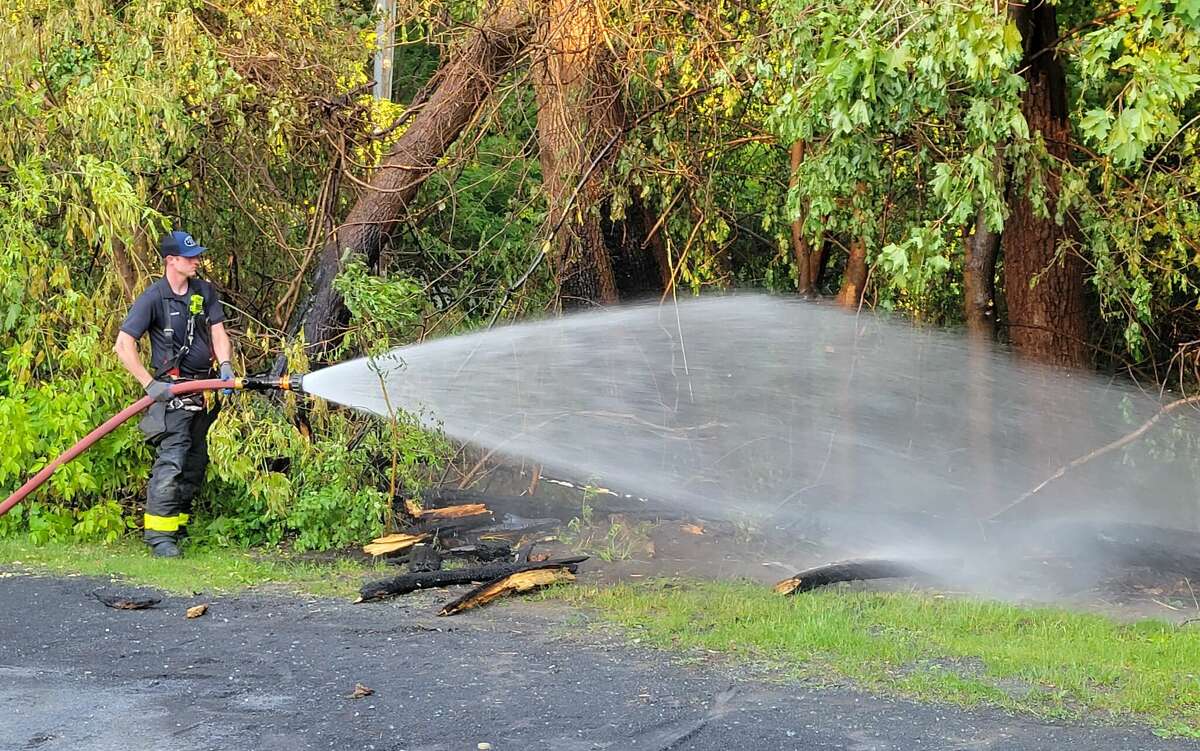 Albany firefighter Colin Nelligan soaks a wooded area at the edge of Buckingham Lake Park near Berkshire Boulevard and Davis Avenue where fire was reported around 6:45 p.m. on Monday, May 29, 2023.