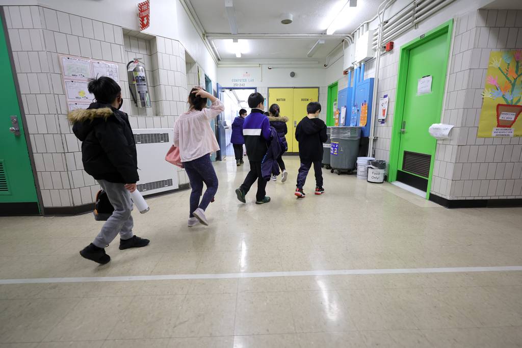 Students are led to their classroom by a teacher at Yung Wing School P.S. 124 on March 07, 2022 in New York City.