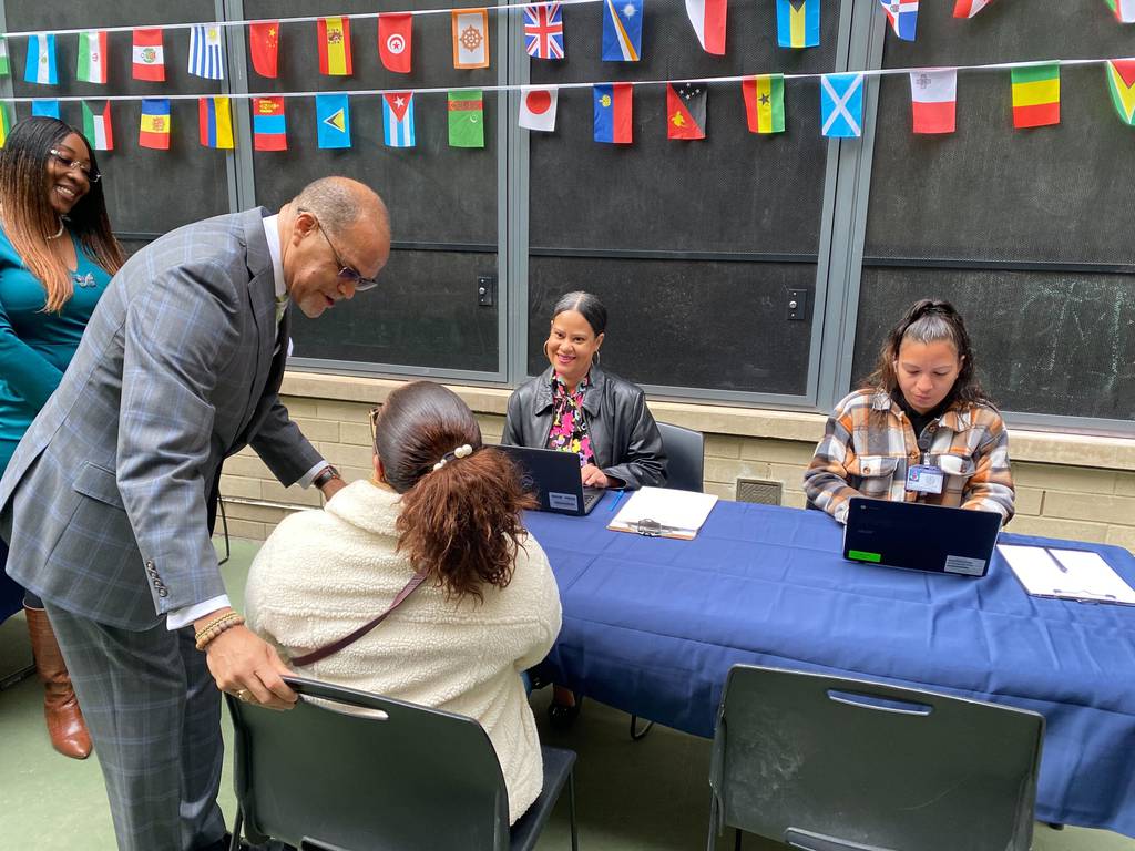 Schools Chancellor David Banks and Department of Youth and Community Development Commissioner Keith Howard help families at P.S 51 in Hell’s Kitchen sign up for the city’s Summer Rising program on April 18, 2023.