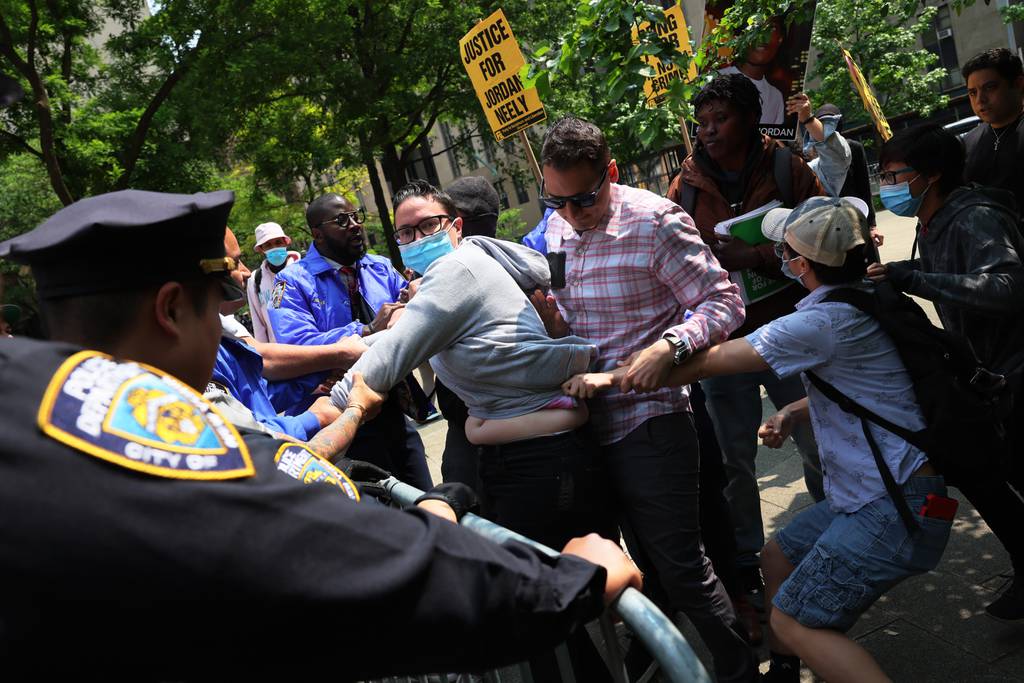 A supporters of Jordan Neely is grabbed by an NYPD officer as they protest a rally in support of Daniel Penny at Collect Pond Park on May 24, 2023 in New York City. 