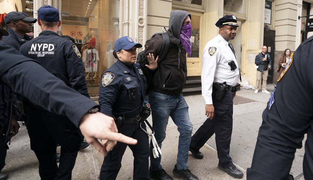 NYPD SRG officers transfer one of three protestors who were arrested for blocking traffic at Broome St. and Broadway to a police vehicle during a march following a vigil for Jordan Neely in the Broadway-Lafayette subway station Wednesday, May 3, 2023,  in Manhattan, New York.