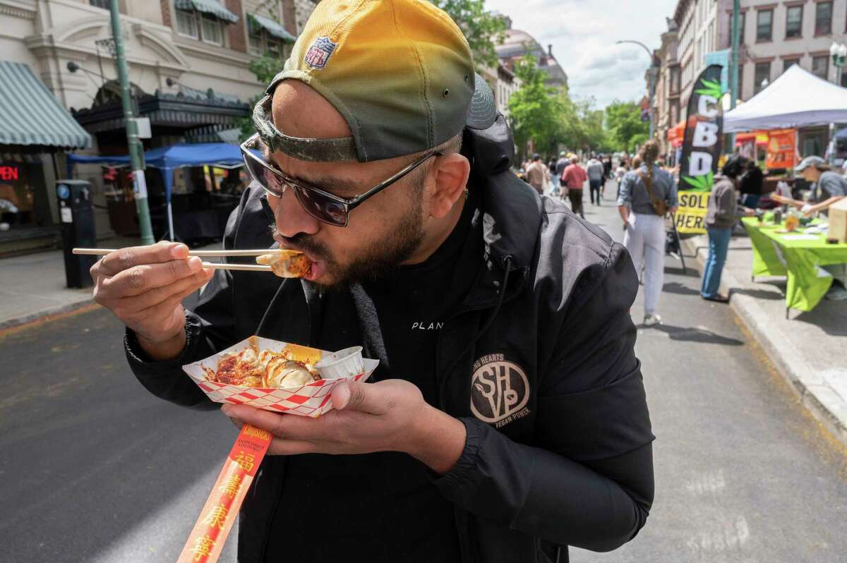 Heimdall Imbert of Latham enjoys an order of dumplings from the Baba Duck booth as the Capital Region Vegan Network holds their annual Veg Out event featuring vegan food from area restaurants on Sunday, June 4, 2023 in Troy, N.Y. Heimball has been vegan for 8 years.