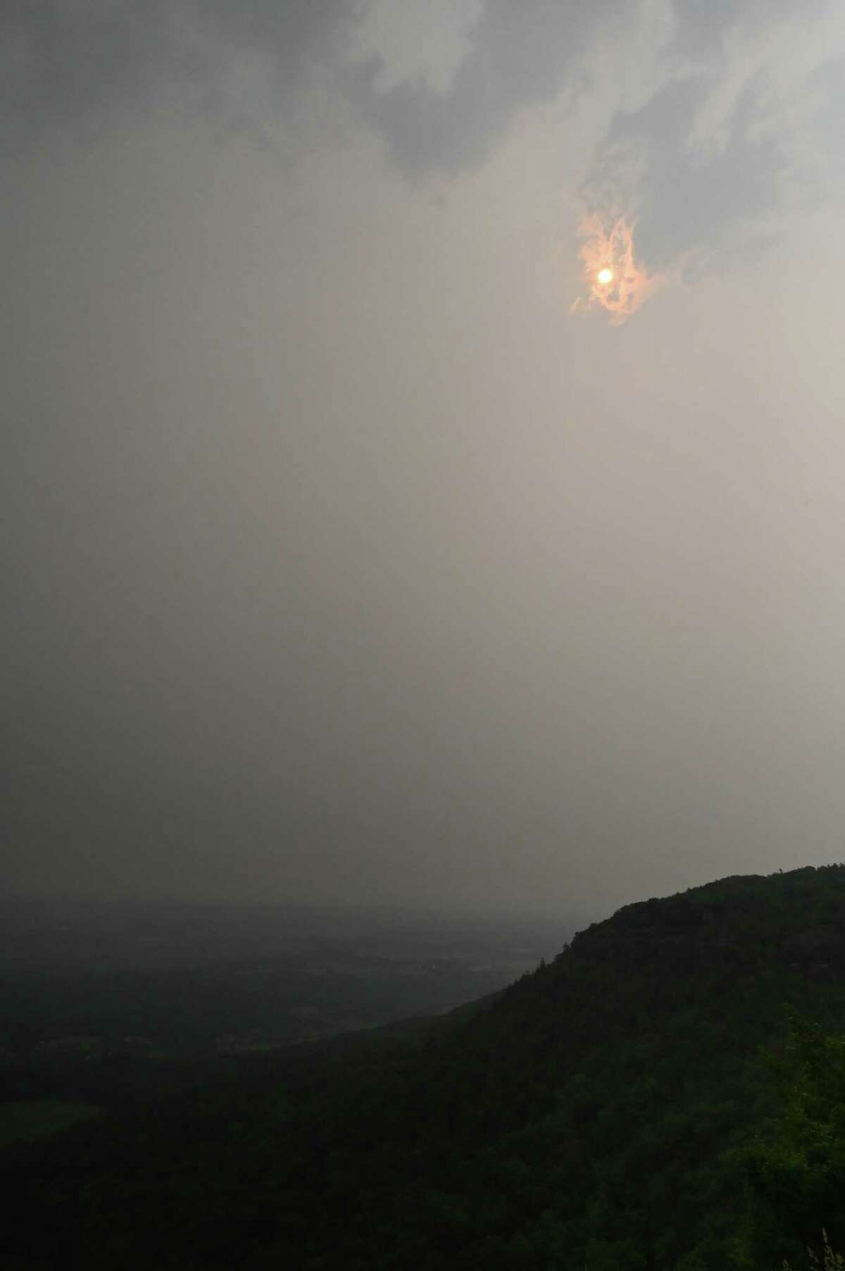 The sun is barely visible above the Overlook at John Boyd Thacher State Park through heavy smoke from Canadian wildfires on Tuesday, June 6, 2023, in New Scotland, N.Y. The region is under an air quality advisory as smoke moves down from the more than 100 active wildfires in burning Quebec.