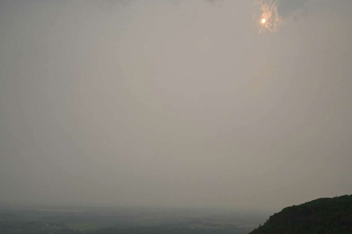 The sun is barely visible above the Overlook at John Boyd Thacher State Park through heavy smoke from Canadian wildfires on Tuesday, June 6, 2023, in New Scotland, N.Y. The region is under an air quality advisory as smoke moves down from the more than 100 active wildfires in burning Quebec.