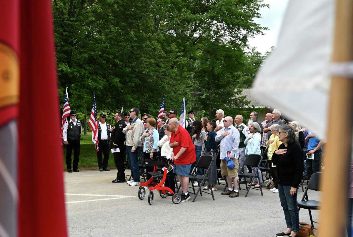 Guests stand for the Pledge of Allegiance during a ceremony to honor Town of Guilderland hometown heroes on Friday at Tawasentha Park in Guilderland. The program honors local heroes who have served and continue to serve in the Armed Forces. Eight new banners were sponsored by the American Legion, Fort Hunter Fire Department and several Guilderland families.