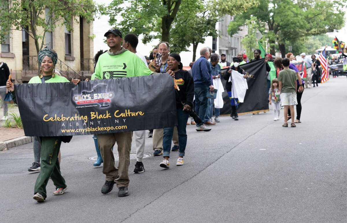 Queen Ghaffar-Adjei and Jamar Board, of the New York State Black Expo and Guardians of Al-Fitrah, carry a banner during the Juneteenth parade that marched from Washington Park to the South End Grocery store on Pearl Street on Saturday, June 17, 2023, in Albany, NY.