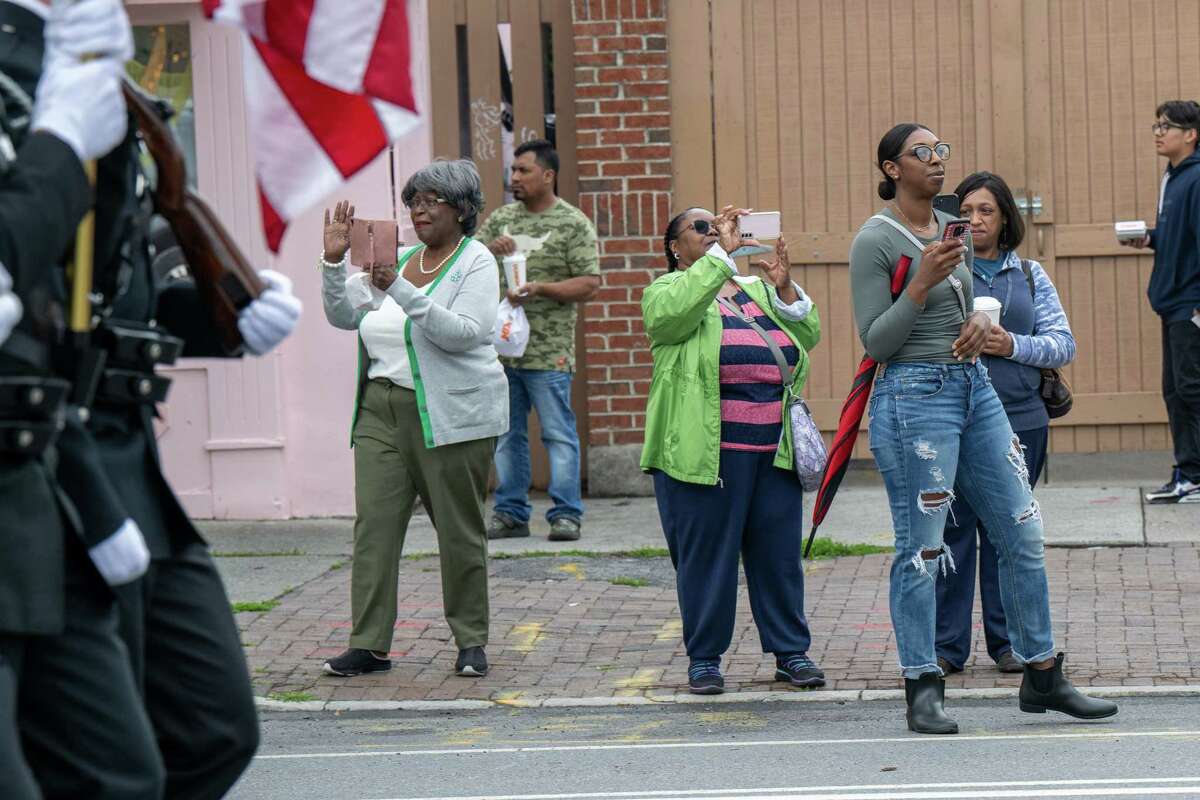 Spectators take photos of the Juneteenth parade that marched from Washington Park to the South End Grocery store on Pearl Street on Saturday, June 17, 2023, in Albany, NY.