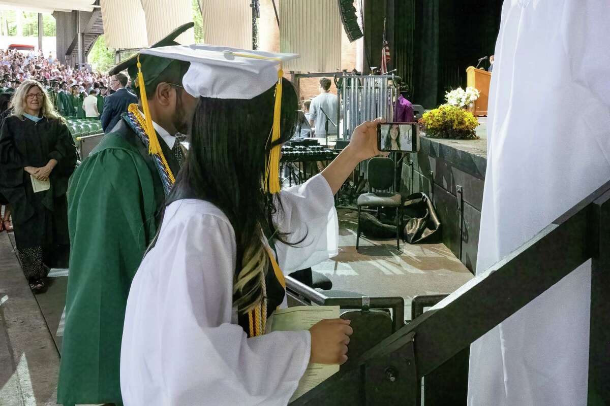 Shenendehowa Class of 2023 Social Media Coordinator Yang Le Foon takes a selfie while walking on stage during her graduation ceremony at the Saratoga Performing Arts Center on Friday, June 23, 2023, in Saratoga, NY.