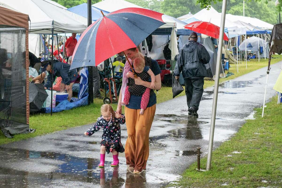 While walking with her mom, Claire Wyman, and sister, Elsie Wyman, Kristina Wyman jumps in a puddle during the Freihofer’s Jazz Fest on Saturday, June 24, 2023, at the Saratoga Performing Arts Center in Saratoga, NY.