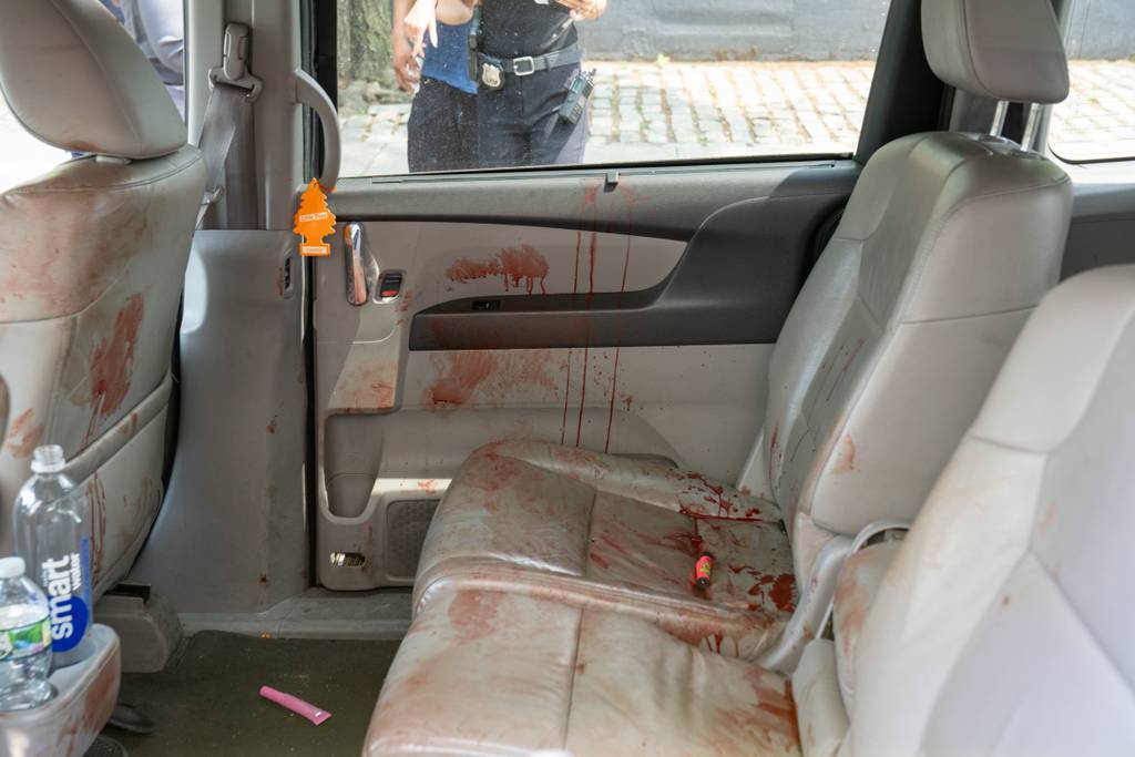 A bullet hole in the rear driver side passenger door could be seen along with blood on said door, as well as blood on the interior of the Livery Cab.