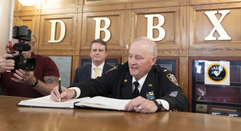 NYPD Det. Lt. Sean O' Toole signs the command log book on his last day at Detective Bureau Bronx Thursday, June 29, in the Bronx. 