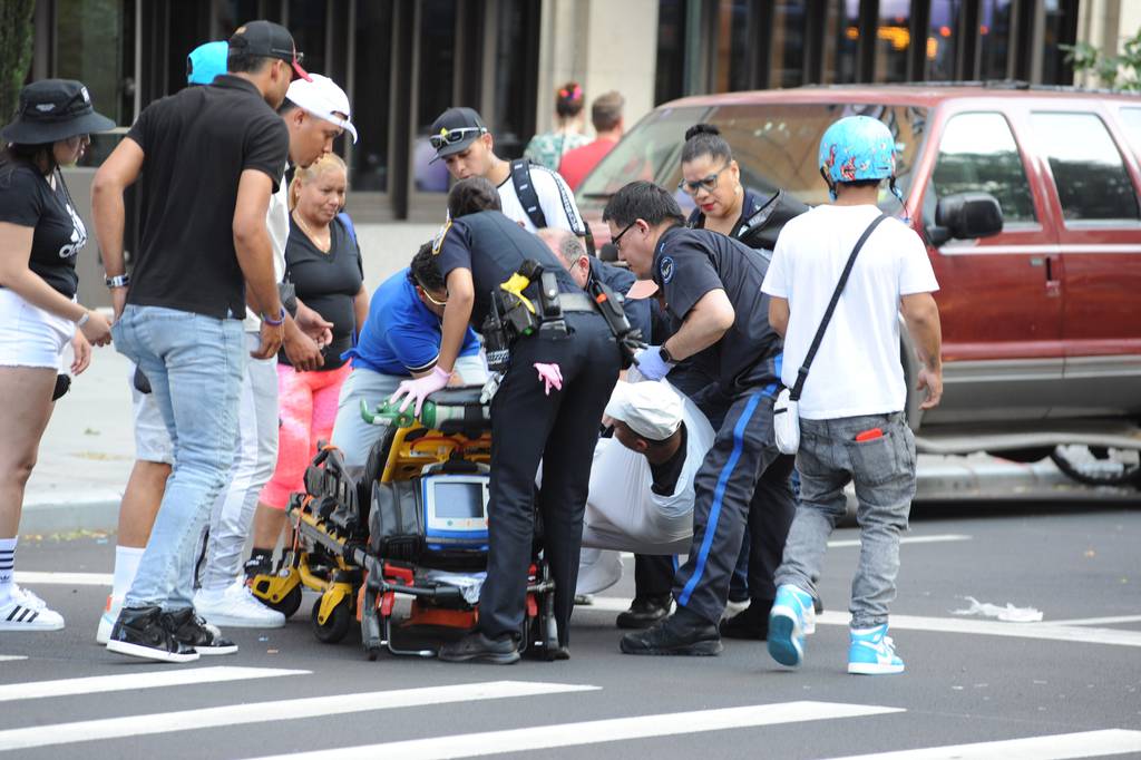 EMS personnel attend to a male who was riding with approximately 50 other motor scooters and motorbikes, on Sunday, June 25, 2023, when he collided with a yellow taxi on Broadway at West 85th street.