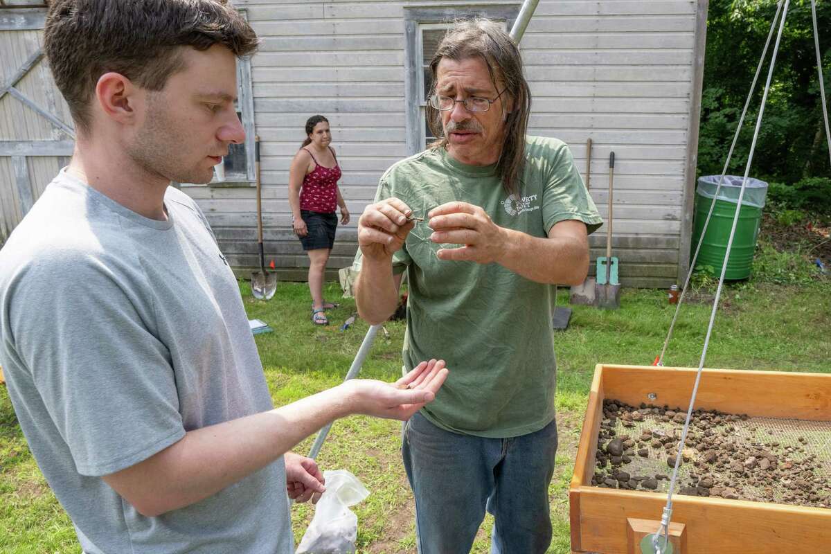 Archeologist Dave Moyer, right, looks at a find by Jared Meisel during a dig at the Historic Grooms Tavern and the adjacent former blacksmith shop on Saturday, July 1, 2023, in Rexford, NY. (Jim Franco/Times Union)