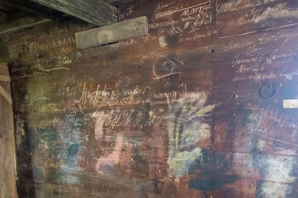 Names of brides and grooms written on the wall of the old blacksmith shop adjacent to the Historic Grooms Tavern on Saturday, July 1, 2023, in Rexford, NY. The blacksmith at the time was also the Clifton Park justice of the peace. (Jim Franco/Times Union)