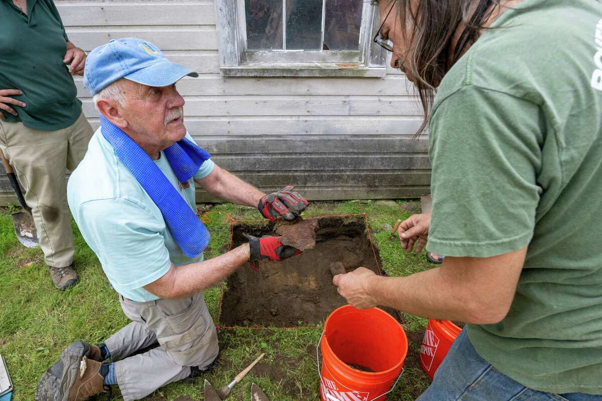 Dan Bradt shows archeologist Dave Moyer a piece of metal unearthed during an archeological dig at the Historic Grooms Tavern and the adjacent former blacksmith shop on Saturday, July 1, 2023, in Rexford, NY. (Jim Franco/Times Union)