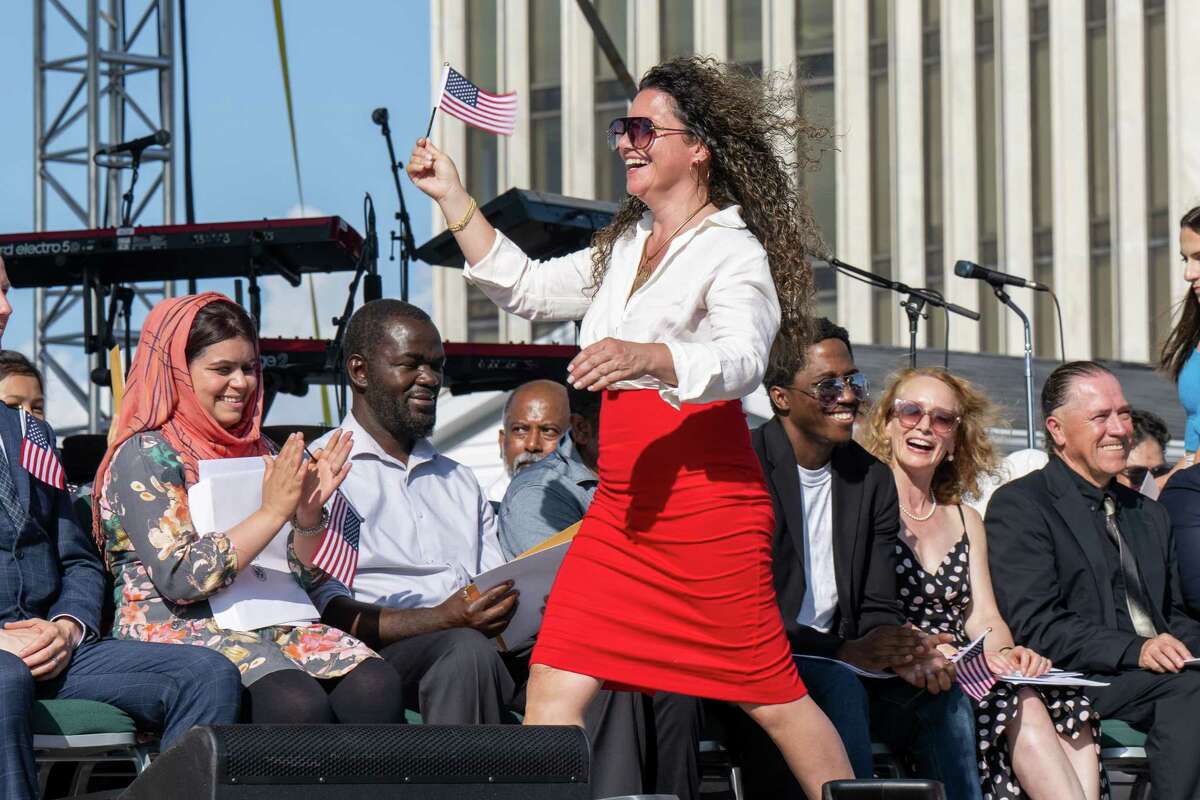 Diana Moschella McGrath, of Canada, waves the American Flag after being sworn in as a U.S. Citizen during a naturalization ceremony at the New York State Fourth of July celebration on the Empire State Plaza on Tuesday, July 4, 2023, in Albany, NY.