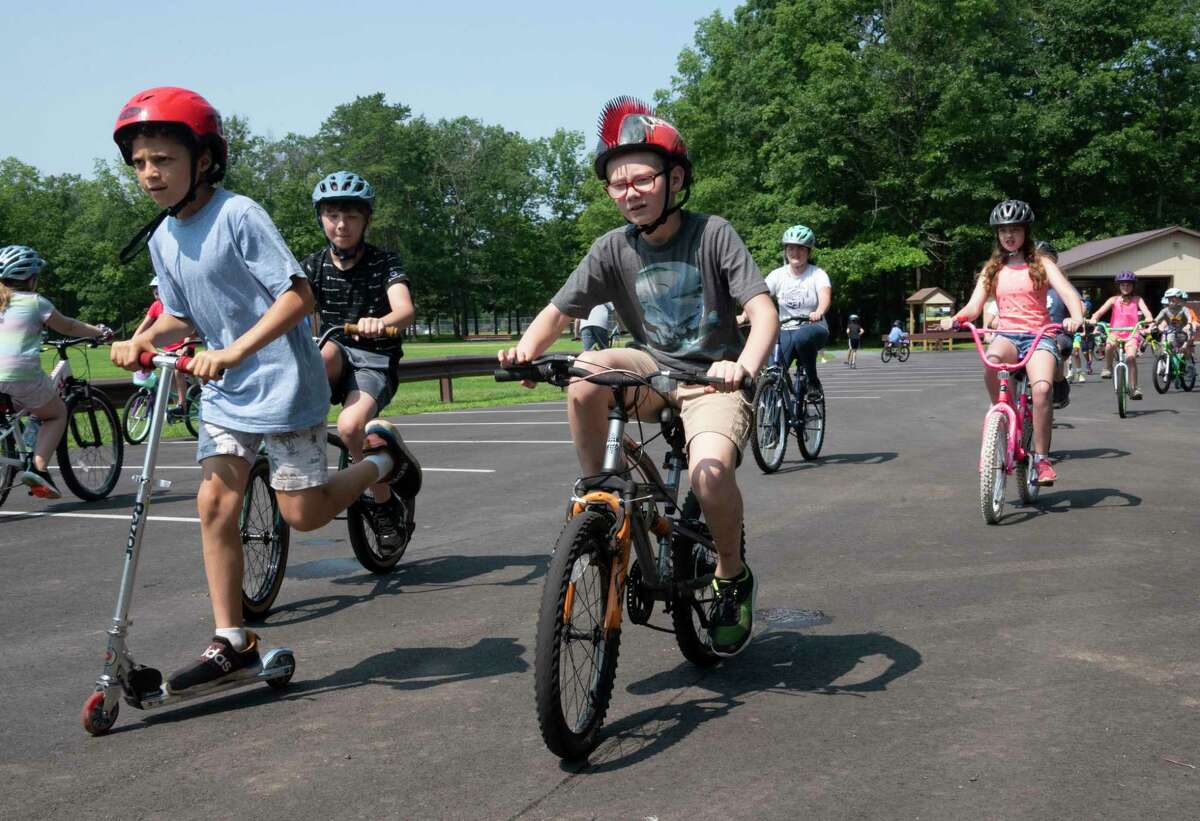 Children ride their bikes and scooters during the 25th annual Safe Summer Bike Helmet Program on Tuesday at Burgess Kimball Memorial Park in Ballston Spa.