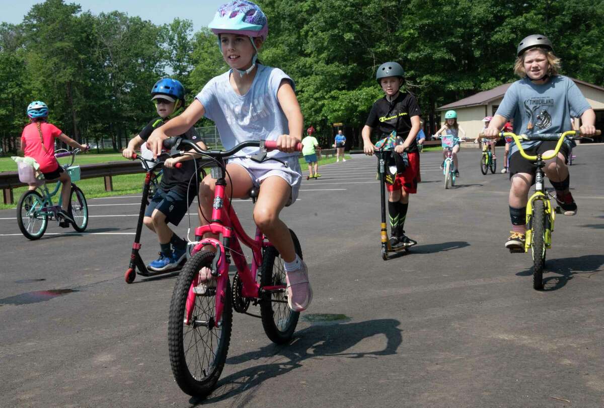 Children ride their bikes and scooters during the 25th annual Safe Summer Bike Helmet Program on Tuesday at Burgess Kimball Memorial Park in Ballston Spa.