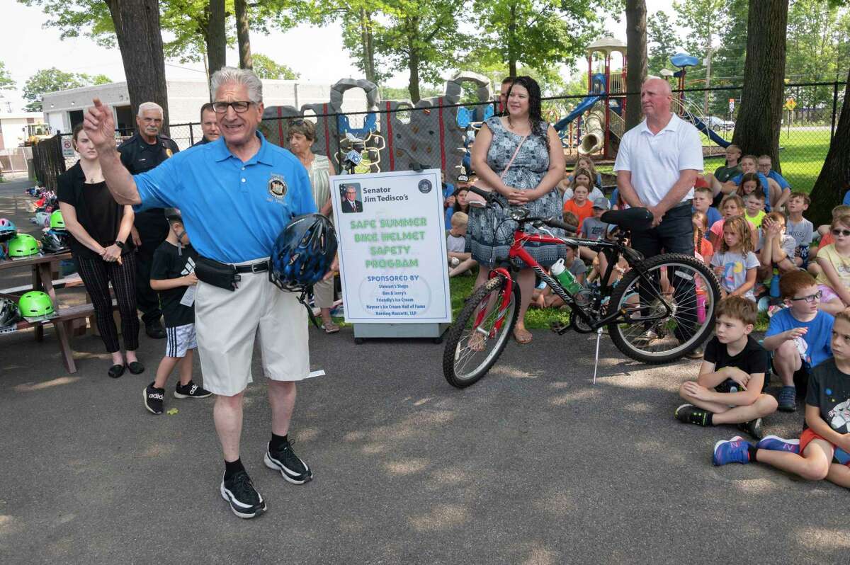 Sen. Jim Tedisco teaches the importance of bike safety and wearing a helmet when riding a bike to children during the 25th annual Safe Summer Bike Helmet Program on Tuesday at Burgess Kimball Memorial Park in Ballston Spa.