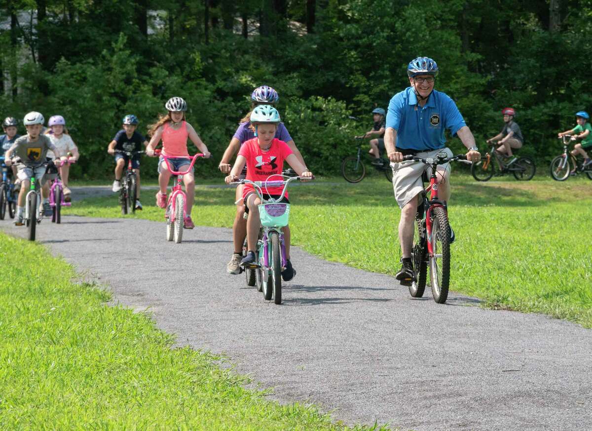 Sen. Jim Tedisco, right, leads a ride as he teaches children the importance of bike safety and wearing a helmet when riding a bike during the 25th annual Safe Summer Bike Helmet Program on Tuesday at Burgess Kimball Memorial Park in Ballston Spa.