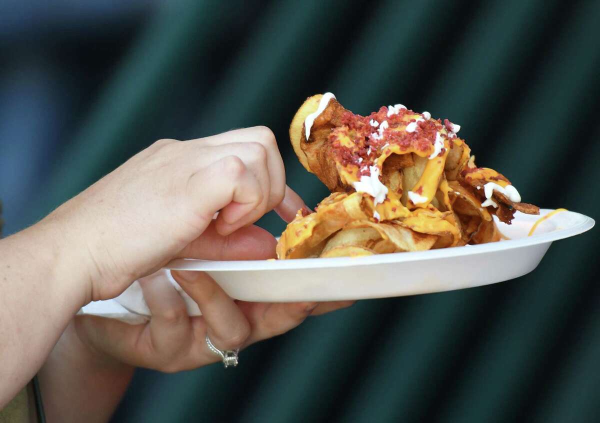 Attendees enjoy barbecue food during the Troy Pig Out on July 13, 2019 at Riverfront Park in Troy.