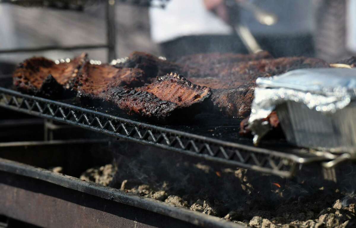 Baby back ribs cook at the Bootlegger's booth during the Troy Pig Out on July 13, 2019 at Riverfront Park in Troy. After a three-year absence, the Troy Pig Out will return Sunday.