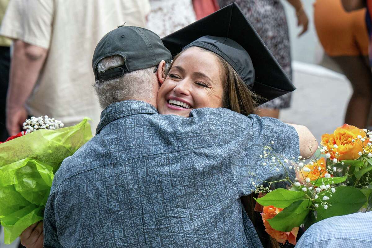 Excelsior University graduate Kelly Pilato hugs her father, Peter McGrath, outside the MVP Arena on Friday in Albany.