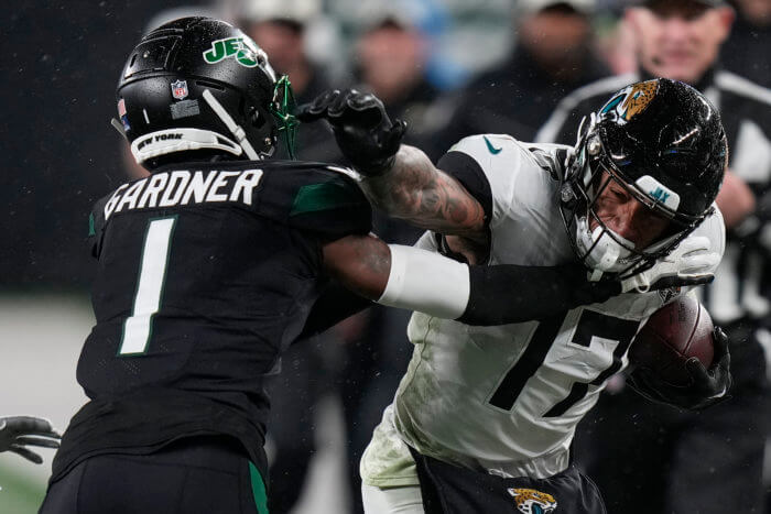 Jaguars tight end Evan Engram stiff-arms Jets cornerback Sauce Gardner.