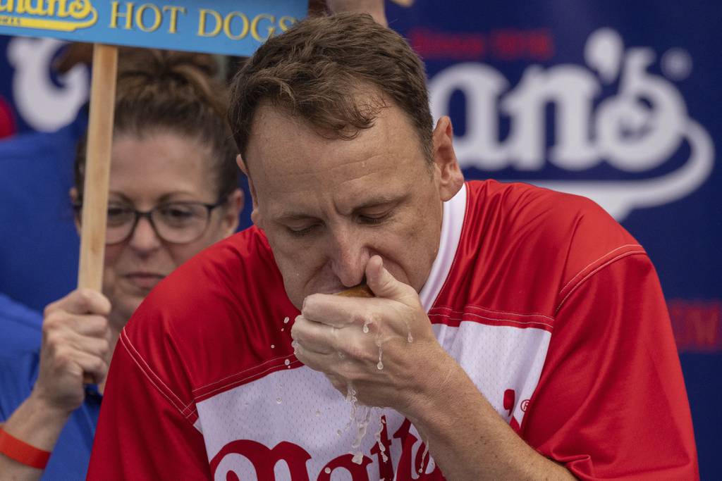 Joey Chestnut eats a hot dog as he competes for his 16th championship title during the 2023 Nathan's Famous Fourth of July hot dog eating contest in Coney Island on Tuesday, July. 4, 2023. 