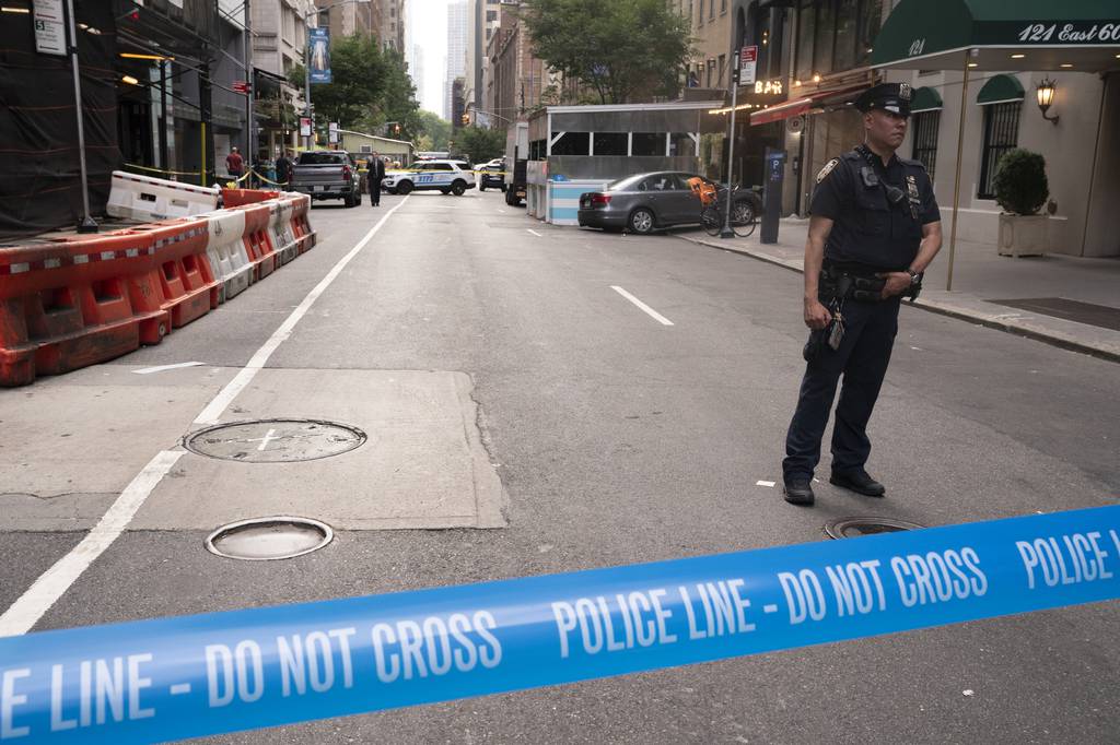 A NYPD officer keeps the crime scene secure on E. 60th St. between Lexington Ave. and Park Ave. Wednesday, July 12, 2023  Manhattan, New York. The 54-year-old driver of a Chevy pickup truck was killed when he was run over by the driver of a VW Jetta.