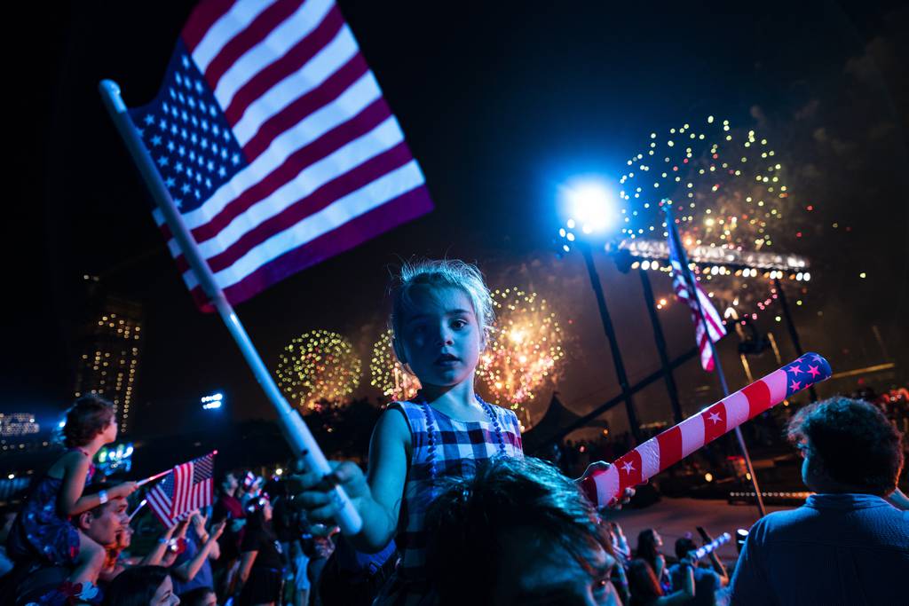 Spectators watch from Queens, New York, as fireworks are launched over the East River and the Empire State Building during the Macy's 4th of July Fireworks show, Sunday, July 4, 2021. 