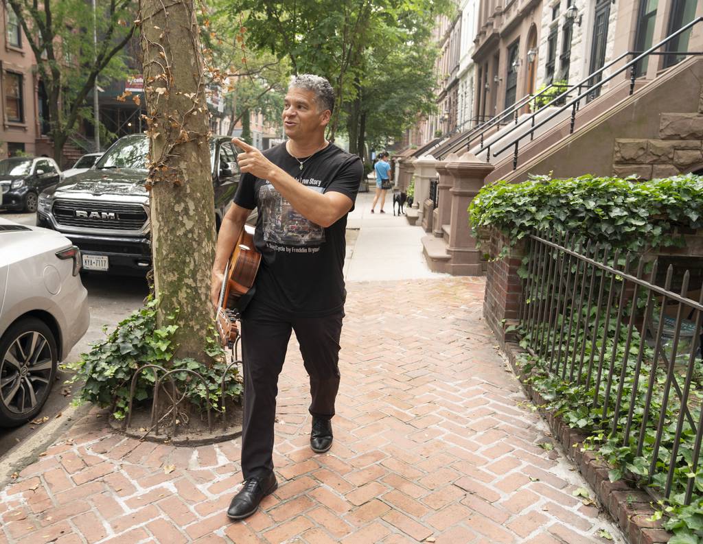 Jazz guitarist Freddie Bryant gestures to a point of interest along his home block on W. 87th St. on Friday, June 30, in Manhattan. 