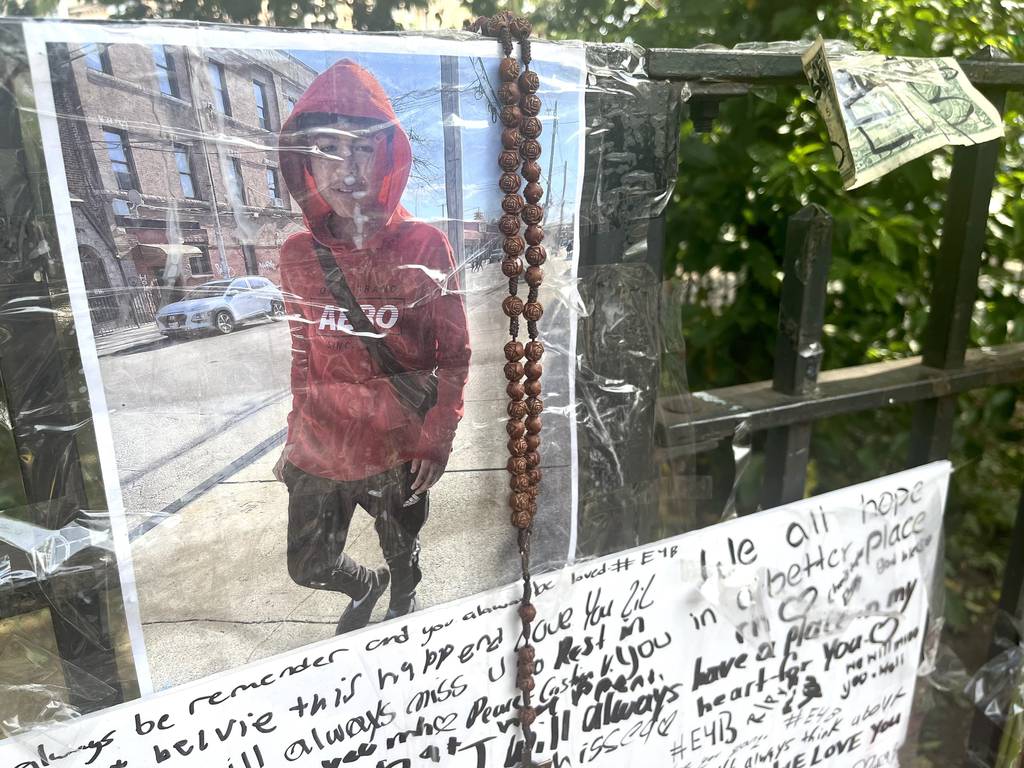 Friends gather at a memorial for Briyan Crespo at Rosemary's Playground in Ridgewood, Queens this afternoon. Candles, posters with loving sentiments, an Ecuadorian Flag, and other mementos can be seen in memory of Briyan Crespo.